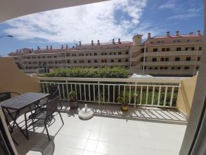 een balkon met een tafel en stoelen en een gebouw bij Sunset Village Apartment - Brisa Da Ericeira in Ericeira