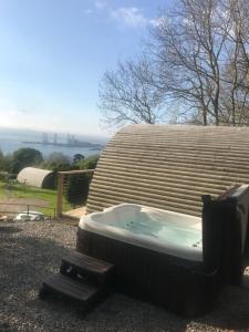 een bad zittend aan de zijkant van een huis bij Sutor Coops The Den with Hot Tub in Cromarty