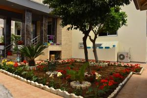 un jardín de flores frente a un edificio en Nora Suit Hotel, en Side