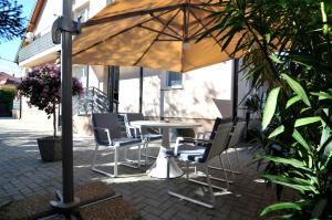 een tafel en stoelen onder een parasol op een patio bij Silver Beach Apartments in Siófok