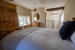 um quarto com uma cama grande e uma janela em Thornes Cottage em Huddersfield