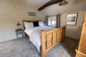 um quarto com uma cama grande e uma estrutura em madeira em Thornes Cottage em Huddersfield