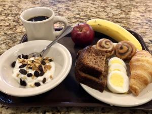 - un plateau avec une assiette de produits pour le petit-déjeuner et une tasse de café dans l'établissement Oasis Guest House, à Boston