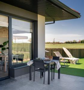 a patio with a table and chairs on a patio at OCEANSUITESLANGRE in Galizano