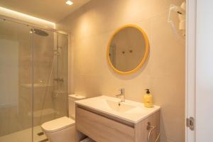 a bathroom with a sink and a toilet and a mirror at OCEANSUITESLANGRE in Galizano