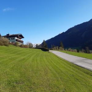 ein Grasfeld neben einer Straße mit einem Haus in der Unterkunft Gästehaus Zum Tauern in Radstadt