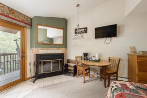 uma sala de estar com uma mesa e uma lareira em Ponderosa Lodge em Estes Park