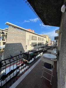 een tafel en stoel op een balkon naast een waterbak bij NG Guest House il Gallura in Olbia