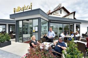 un gruppo di persone seduti fuori da un ristorante di Hotel Restaurant Fallerhof a Bad Krozingen