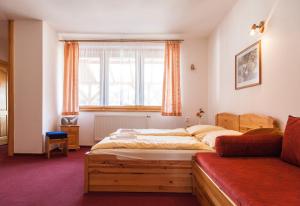 1 dormitorio con 2 camas y ventana en Penzion Snezienka, en Tatranská Lomnica