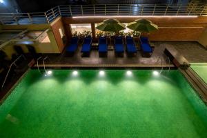 an overhead view of a swimming pool with chairs and umbrellas at Welcomhotel by ITC Hotels, RaceCourse, Coimbatore in Coimbatore