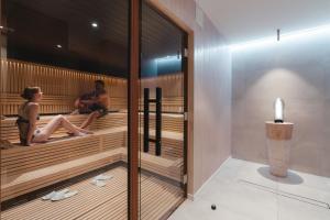 una pareja sentada en una sauna en Alpen Resort & Spa, en Zermatt