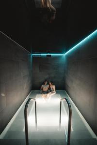 Dos personas están sentadas en una bañera con luces en Alpen Resort & Spa, en Zermatt