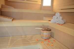 uma sauna com um balde e toalhas no chão em Villa Buchenhain em Ehrwald