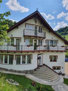 a large white house with a balcony and stairs at Casa Destinatia Perfecta in Braşov