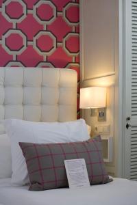 um quarto com uma cama com uma parede vermelha em Hotel New York by WestCord em Roterdão