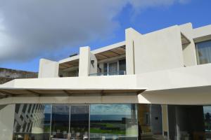 - un bâtiment blanc avec vue sur l'océan dans l'établissement Pousada de Angra do Heroismo Castelo de S. Sebastiao, à Angra do Heroísmo