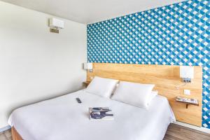 pokój hotelowy z łóżkiem z książką w obiekcie Kyriad Montauban Sud - Albasud w mieście Montauban