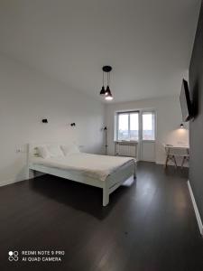 een witte slaapkamer met een bed en een tafel bij White Apartment in Poltava