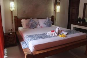 a bedroom with two beds with flowers on them at Jukung Villas Kuta in Kuta