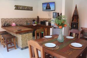 a dining room table with a vase of flowers on it at Jukung Villas Kuta in Kuta