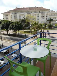 uma mesa e cadeiras numa varanda com um edifício em Hotel Alexandra Sitges em Sitges