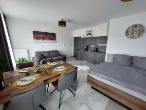 ein Wohnzimmer mit einem Tisch und einem Bett in der Unterkunft Apartmán Rezidence Javor Železná Ruda in Železná Ruda