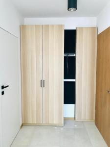 a kitchen with wooden cabinets in a room at Stadium Apart Terrace in Warsaw