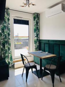 a table and chairs in a room with a window at Stadium Apart Terrace in Warsaw