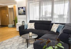 a living room with a black couch and a table at Sea&City Deluxe Apartment - Top Center Varna in Varna City