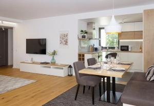 a kitchen and living room with a table and chairs at Sea&City Deluxe Apartment - Top Center Varna in Varna City