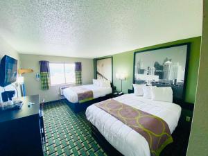 ワイオミングにあるSuper 8 Grand Rapids City Centerのベッド2台と大きな窓が備わるホテルルームです。