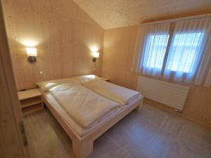 um quarto com uma cama num quarto com uma janela em Holiday Home Maiensäss Superior by Interhome em Urmein