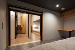 1 dormitorio con una gran puerta de cristal que conduce a una cama en hotel atarayo osaka, en Osaka