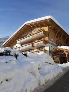 a building with snow in front of it at Hotel les Sapins in La Clusaz