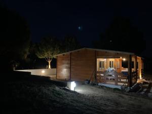 uma pequena cabana de madeira à noite com luzes em Moinho de Vento (CASA DE MADEIRA) em Castelo Branco