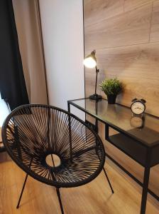 een tafel en een stoel en een tafel met een klok bij Apartament Loftowy Wypoczynek GoldAir in Poznań