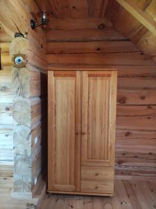 a wooden cabin with a door in a room at Lāču namiņš/Bear house in Liepāja