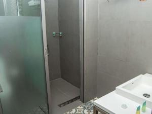 una ducha con una puerta de cristal junto a un lavabo en Ibis Styles Dubai Jumeira, en Dubái