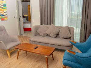 Sala de estar con sofá, 2 sillas y mesa de centro en Ibis Styles Dubai Jumeira, en Dubái