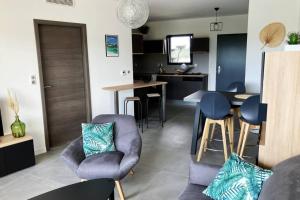 uma sala de estar com um sofá e cadeiras e uma cozinha em Appartement Stanatura - Standing - Proche du port - 4 personnes - 1 chambre em Porto-Vecchio