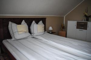 a large white bed with white pillows on it at Golden BIS, Subotica in Subotica