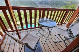 a table and two chairs on a wooden deck at Les Balcons du Molliebon in Séez