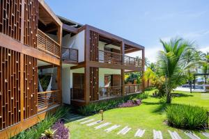 ein Haus mit Holzbalkonen und einem Hof in der Unterkunft Pousada Encanto da Lua in Barra Grande