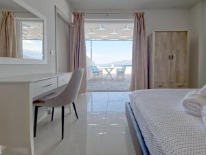 ナフパクトスにあるEpipleon Luxury Suites -105- Δωμάτιο 35τμ με βεράντα 35τμ μπροστά στη θάλασσαのベッドルーム(デスク、鏡付きベッド1台付)