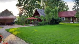 una casa con un ampio giardino con una casa di Wiśniowy Sad - Domki a Białowieża