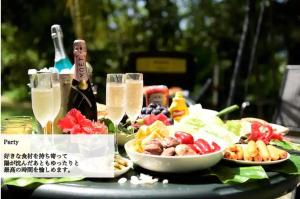 a table with plates of food and a bottle of champagne at Scallop Beach Condominium in Onna