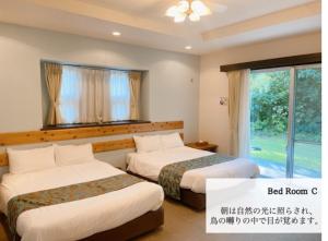 a hotel room with two beds and a window at Scallop Beach Condominium in Onna