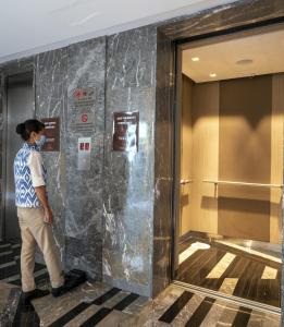 a man wearing a face mask walks past a hotel lobby at Welcomhotel by ITC Hotels, RaceCourse, Coimbatore in Coimbatore