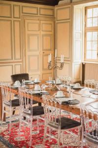 un comedor con una gran mesa de madera y sillas en Château de la Cour Senlisse, en Senlisse